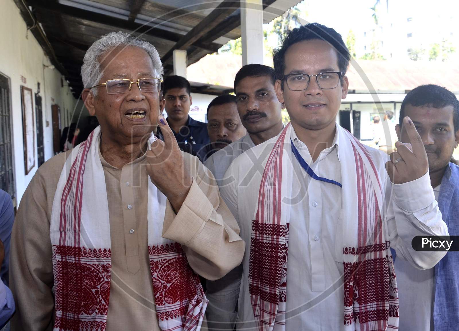 Former Assam Chief Minister Tarun Gogoi and His son Gourav Gogoi shows their ink-marked finger