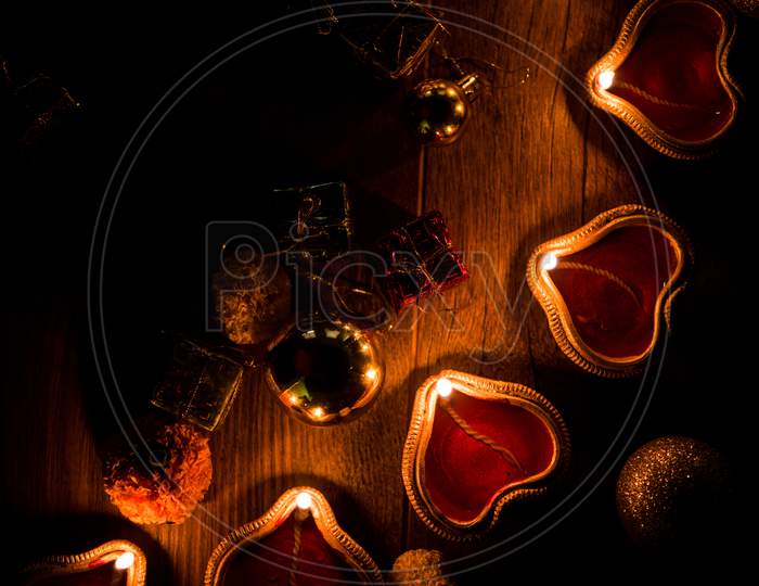 Diwali diyas at night with flowers, lighting series and gifts