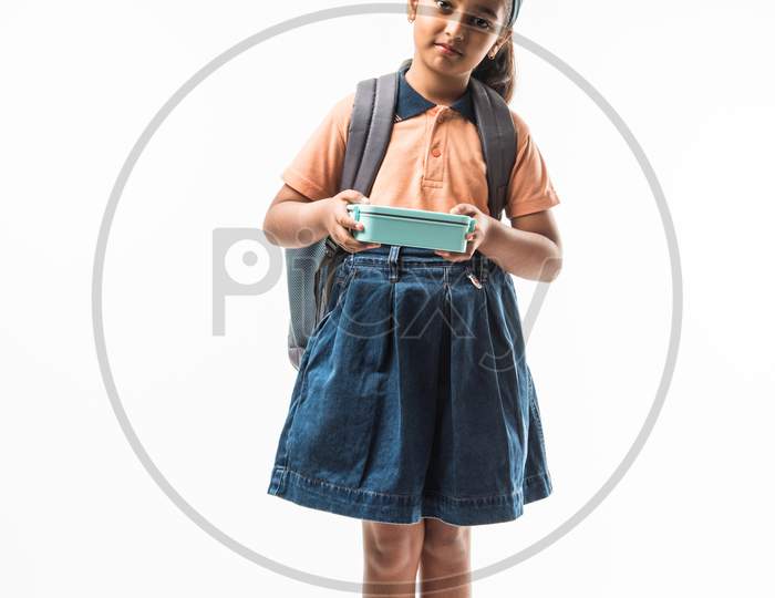 Indian girl in school uniform, standing isolated over white background ready to leave