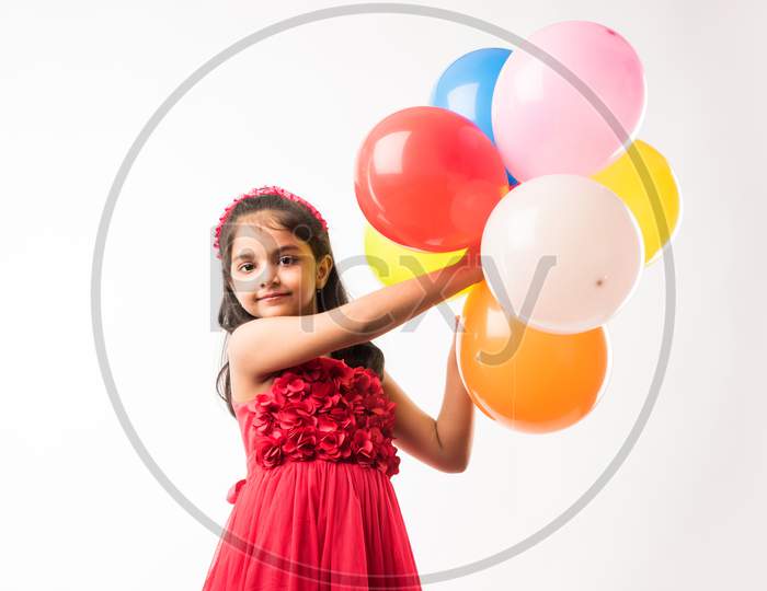 cute little indian/asian girl with colourful balloons or gubbare in Hindi, over white or red background