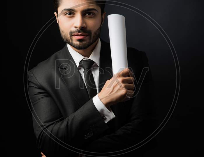 Indian Bearded Male businessman holding or reading documents or paper Roll while standing isolated over white background