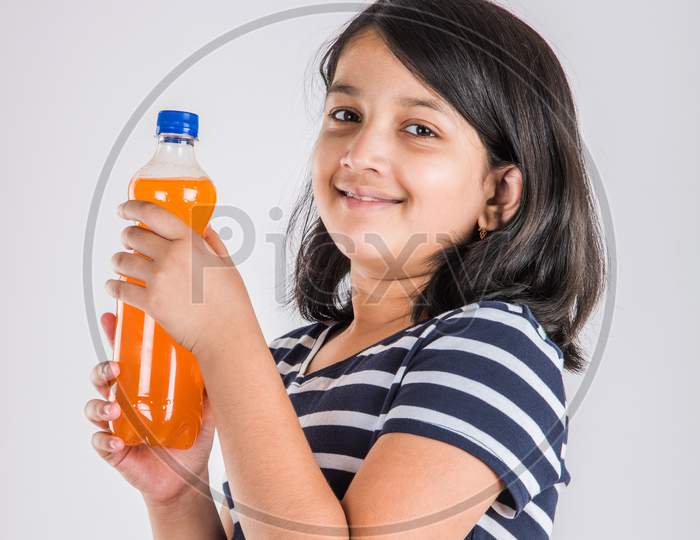 Cute little girl drinking mango juice or cold drink / beverage