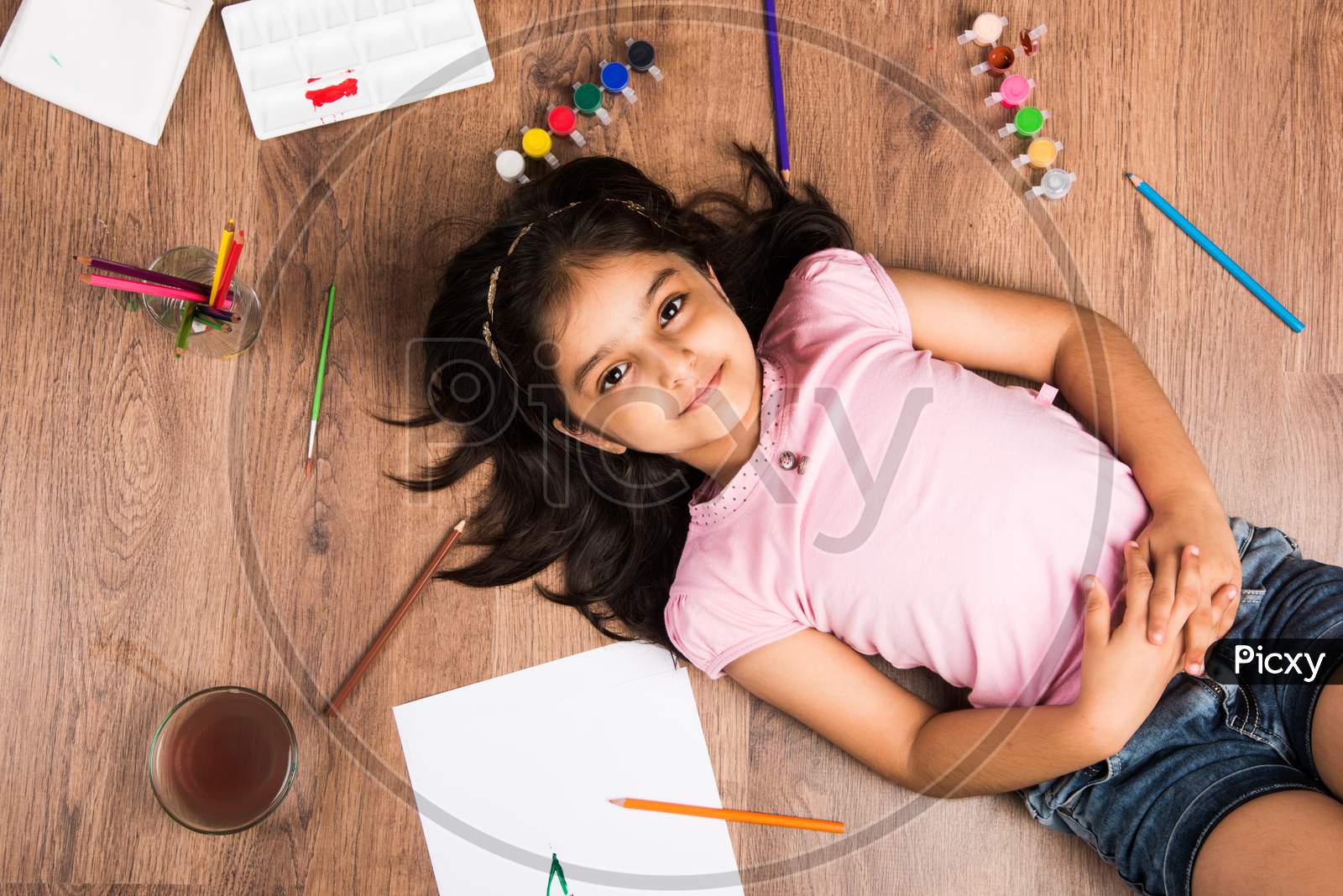 Cute little girl drawing with pencils and colours