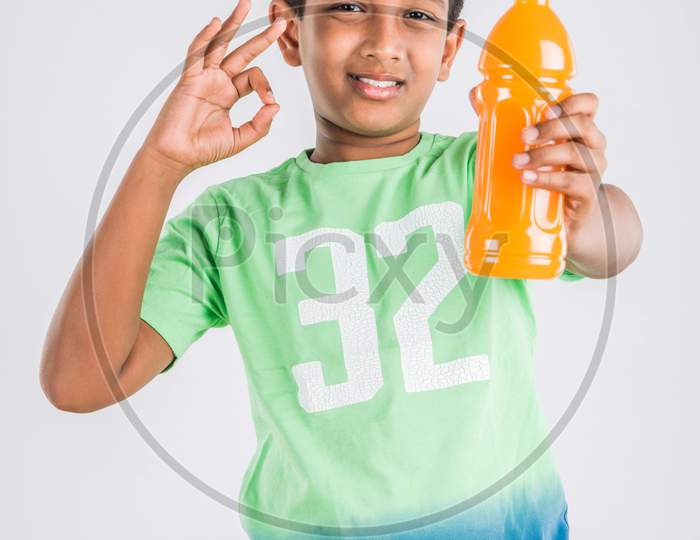 Cute little boy drinking mango juice or cold drink / beverage