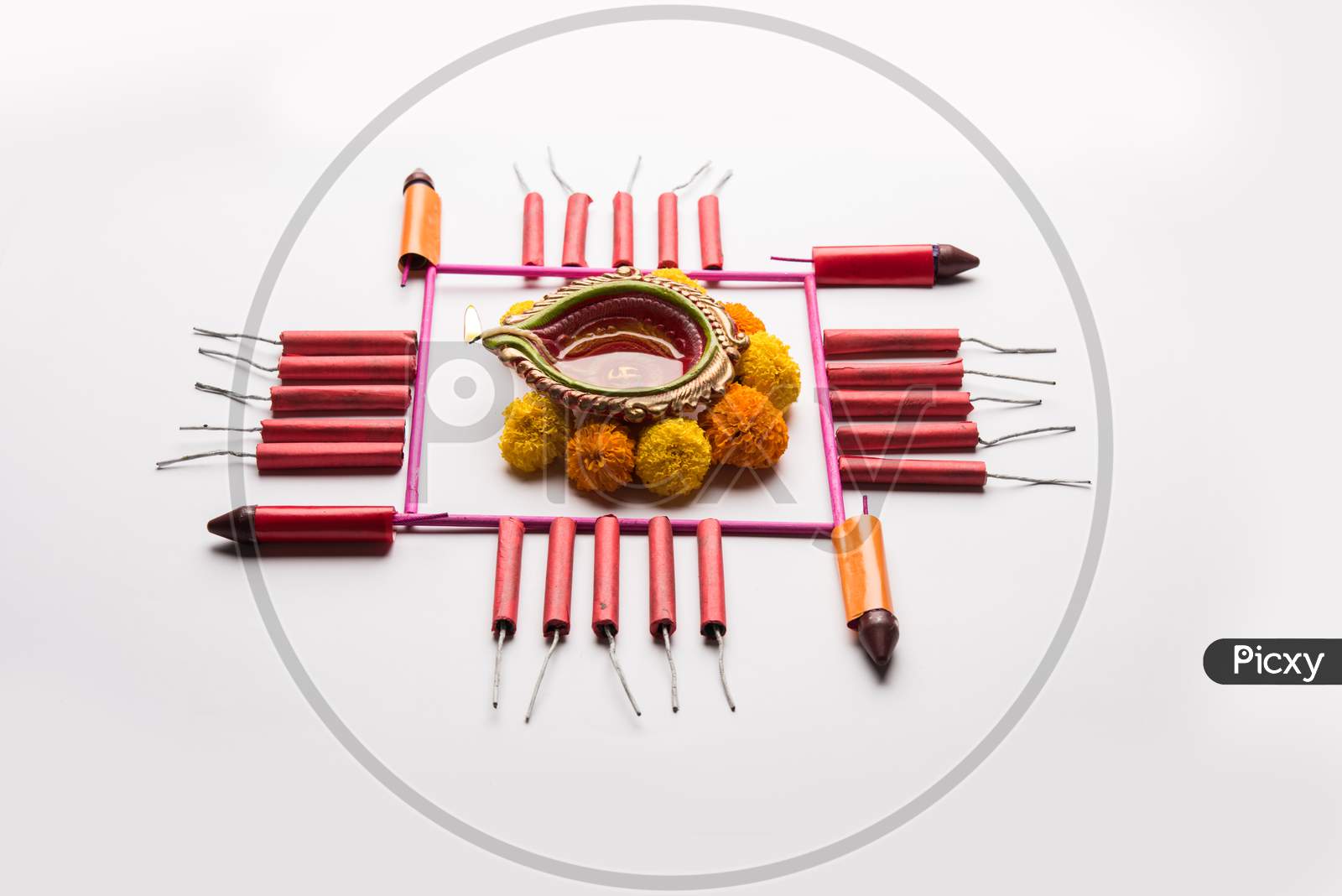 diwali rangoli using snacks, firecrackers and oil lamp or diya
