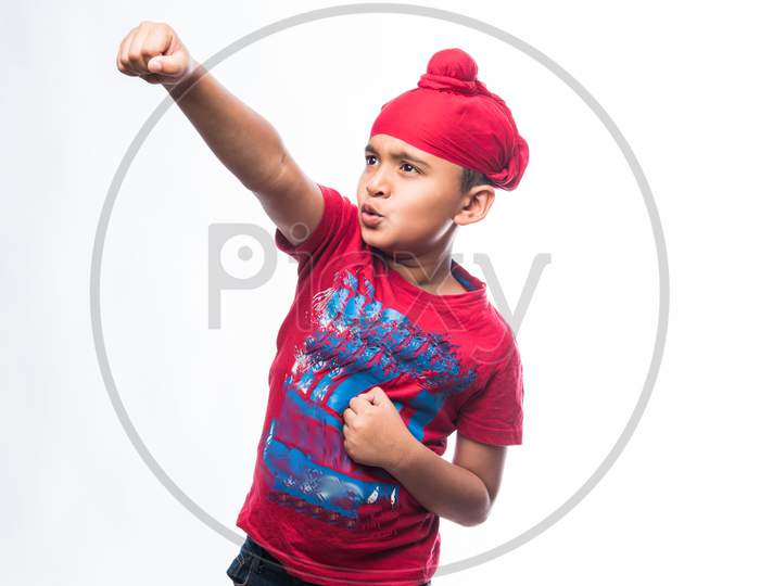 Portrait of Indian Sikh/punjabi little boy standing isolated over white background