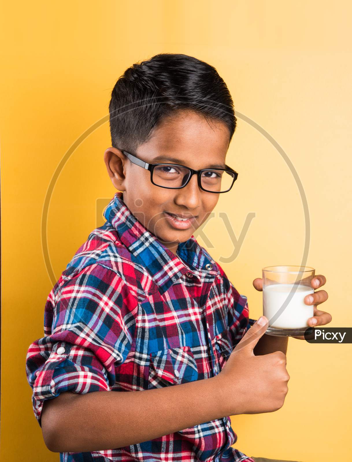 Small boy drinking plain milk in a glass