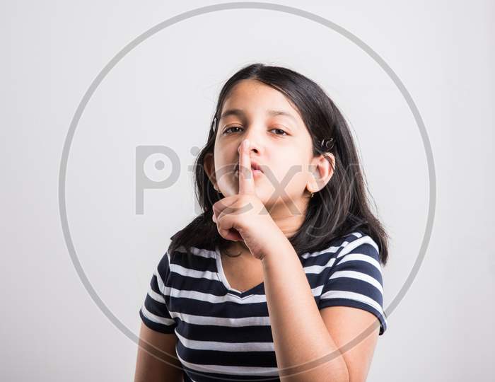 Cute little indian showing keep silence sign