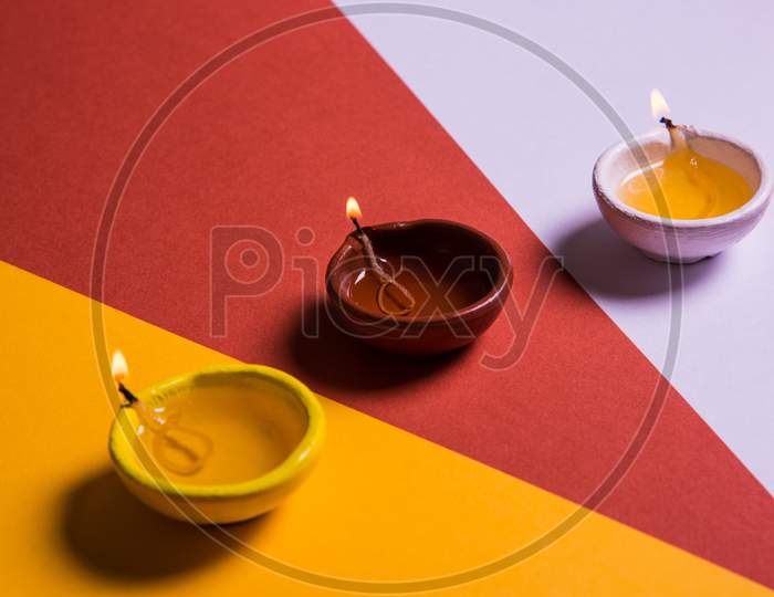 Colourful Diwali diya on colourful background, selective focus