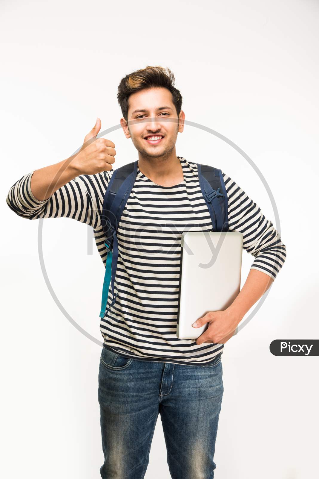 Young male college student standing with bag and books/laptop computer, isolated over white background
