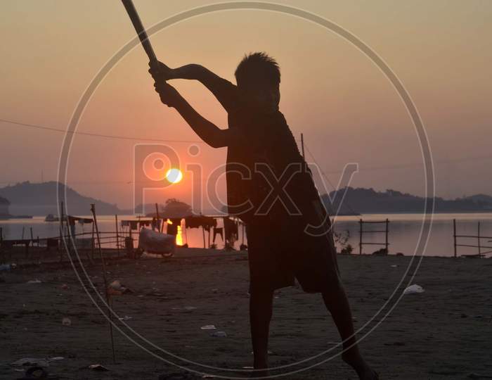 Boys playing cricket during Silhouette