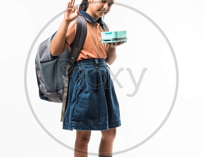 Indian girl in school uniform, standing isolated over white background ready to leave