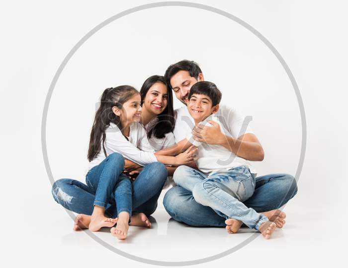 Young family sitting isolated over white