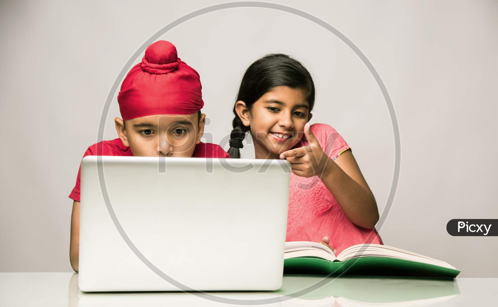Indian Sikh/punjabi little boy studying with laptop and books at study table