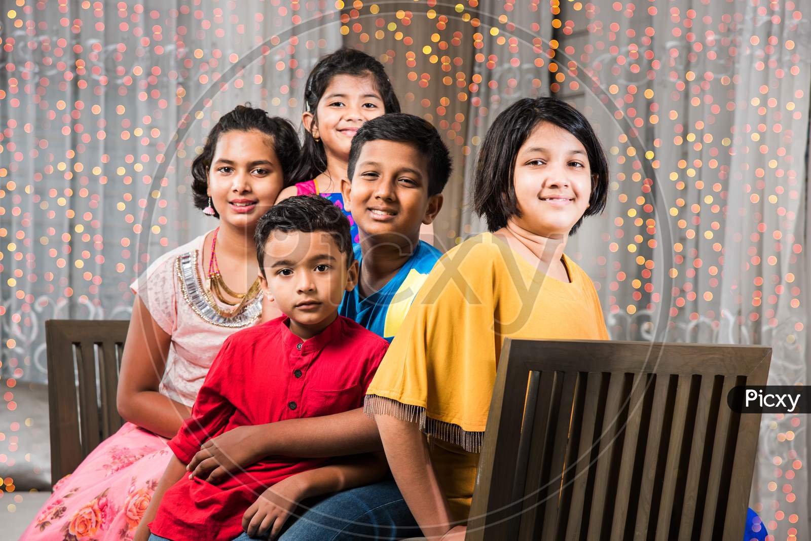 Portrait of Indian kids sitting on Sofa/Couch on diwali Festival night