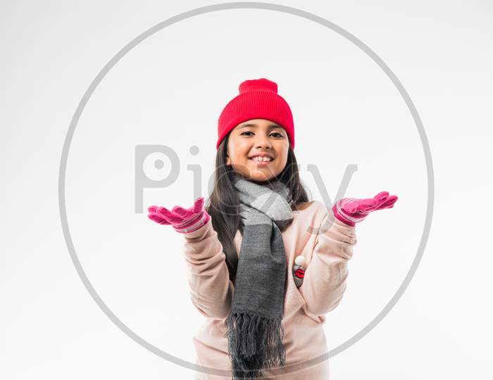 Indian cute little girl in winter wear, standing against white background