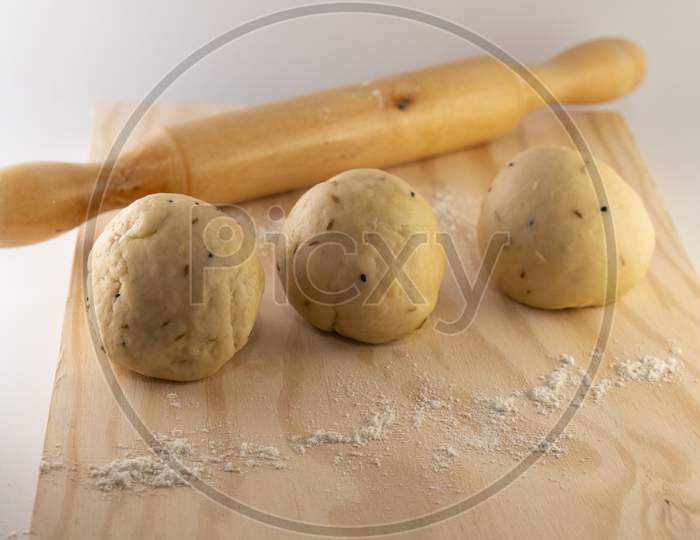dough on rolling board with a rolling pin .
