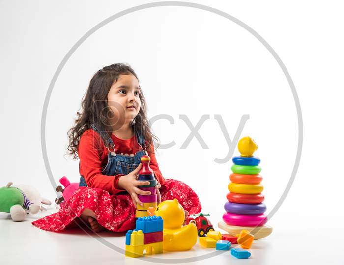 Indian Little child girl with stethoscope and Stuffed Baby or Puppy toy sitting against white background
