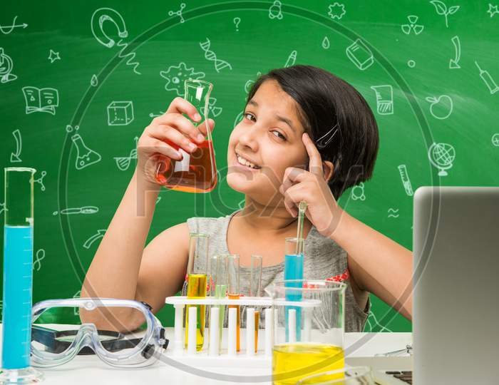 Cute little school girl studying science