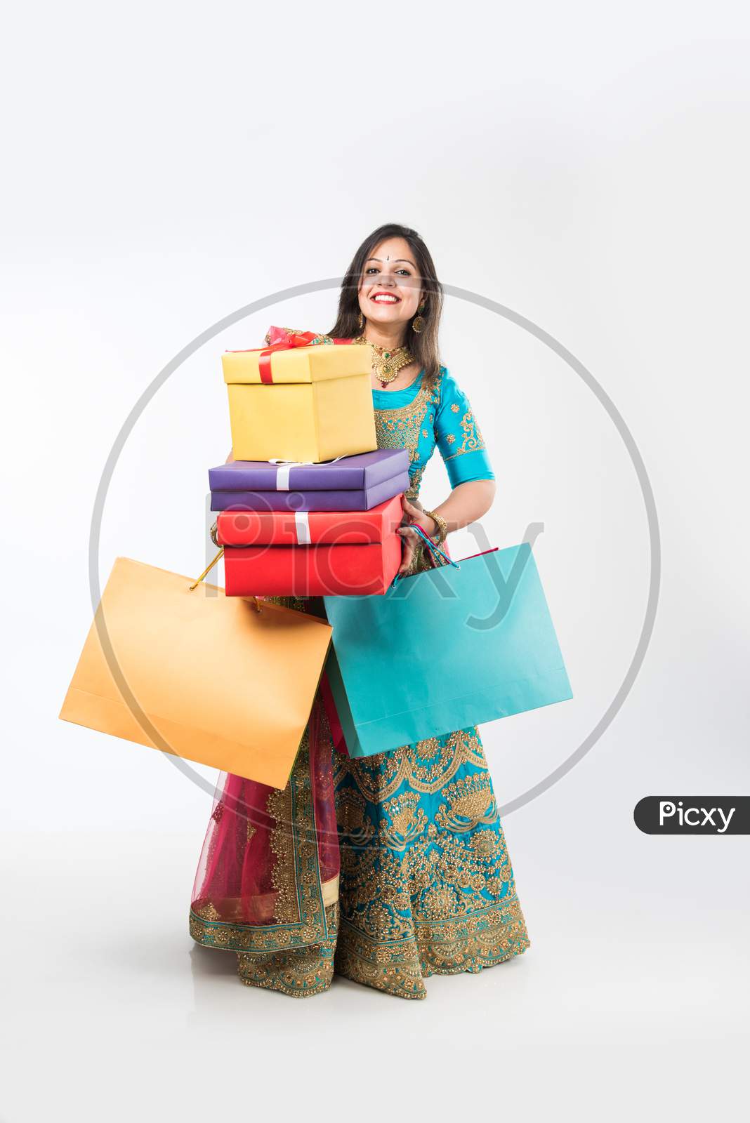 Indian girl with Shopping bags and gift boxes, standing isolated over white background
