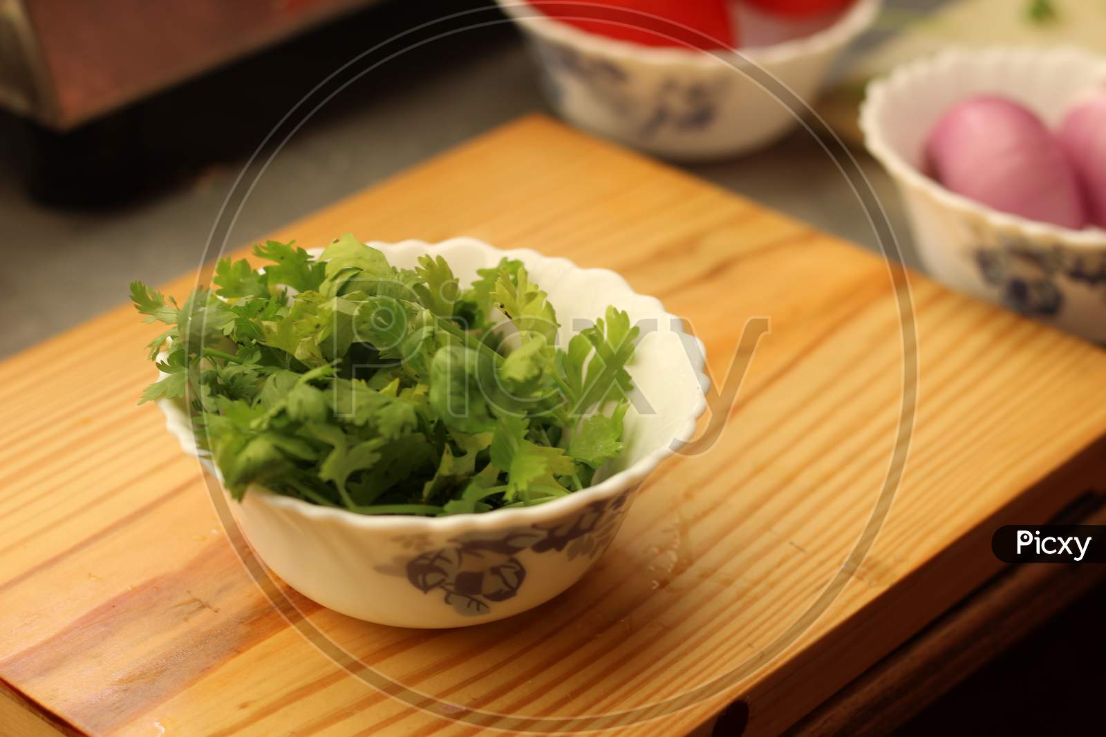 Coriander leaves on a white bowl.