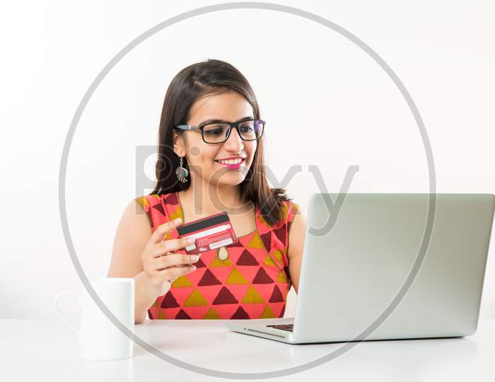 Girl online shopping using debit/credit card on laptop computer