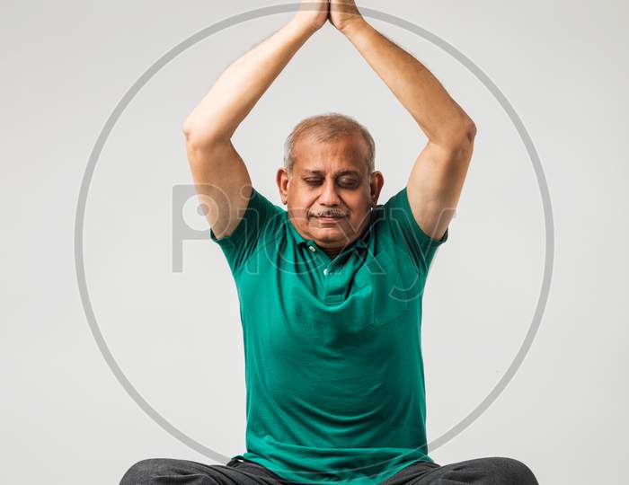 Senior indian man doing yoga or meditation
