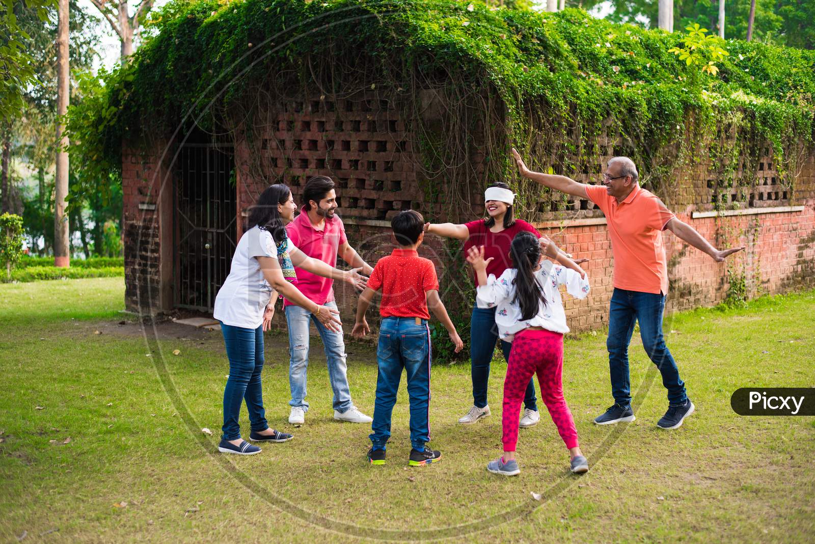 Indian Family playing blindfold game in park or garden
