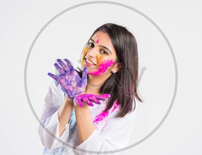 indian people celebrating Holi, festival of colours with plates full of colours and faces painted, happiness concept, standing i