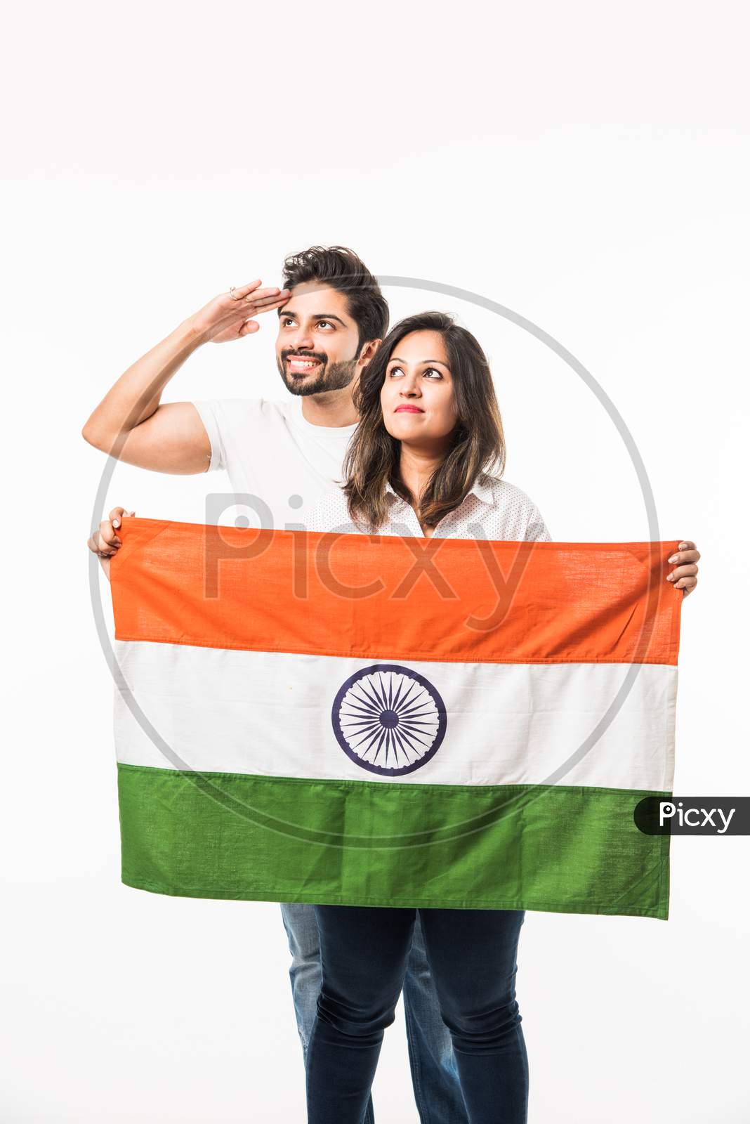 Young Couple holding Indian Flag on Independence or republic day, standing isolated over white background. selective focus