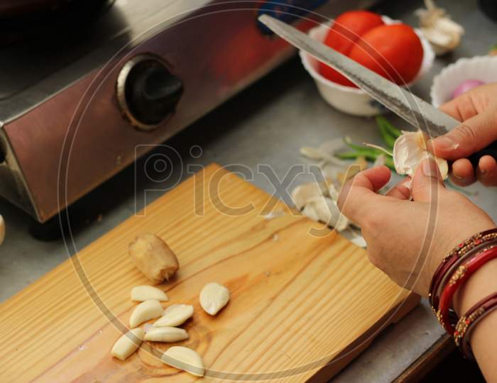 Woman Cutting Garlic by Knife.