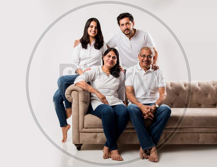 Indian/asian family sitting on sofa or couch over white background