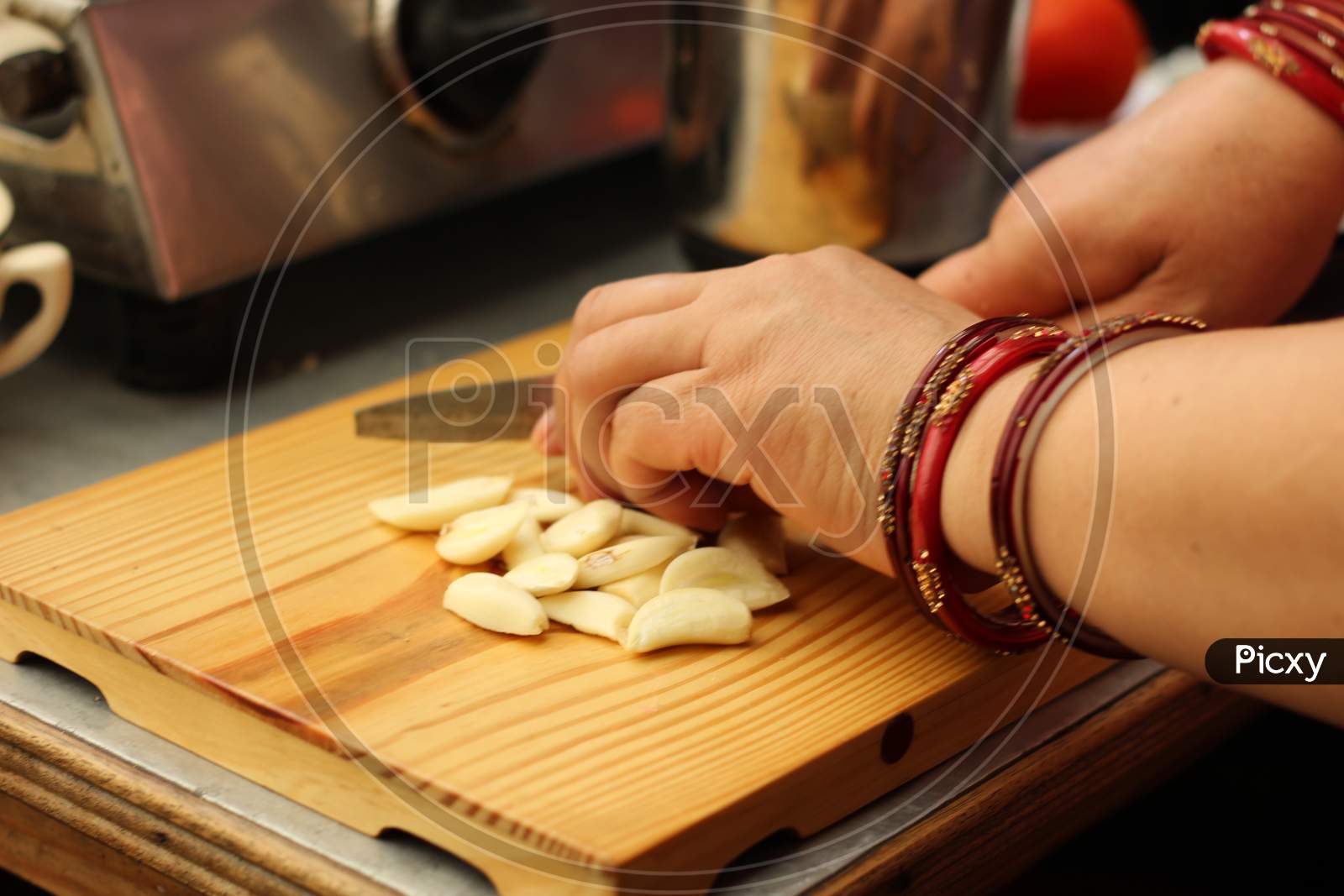 Woman Cutting Garlic On Chopping Board