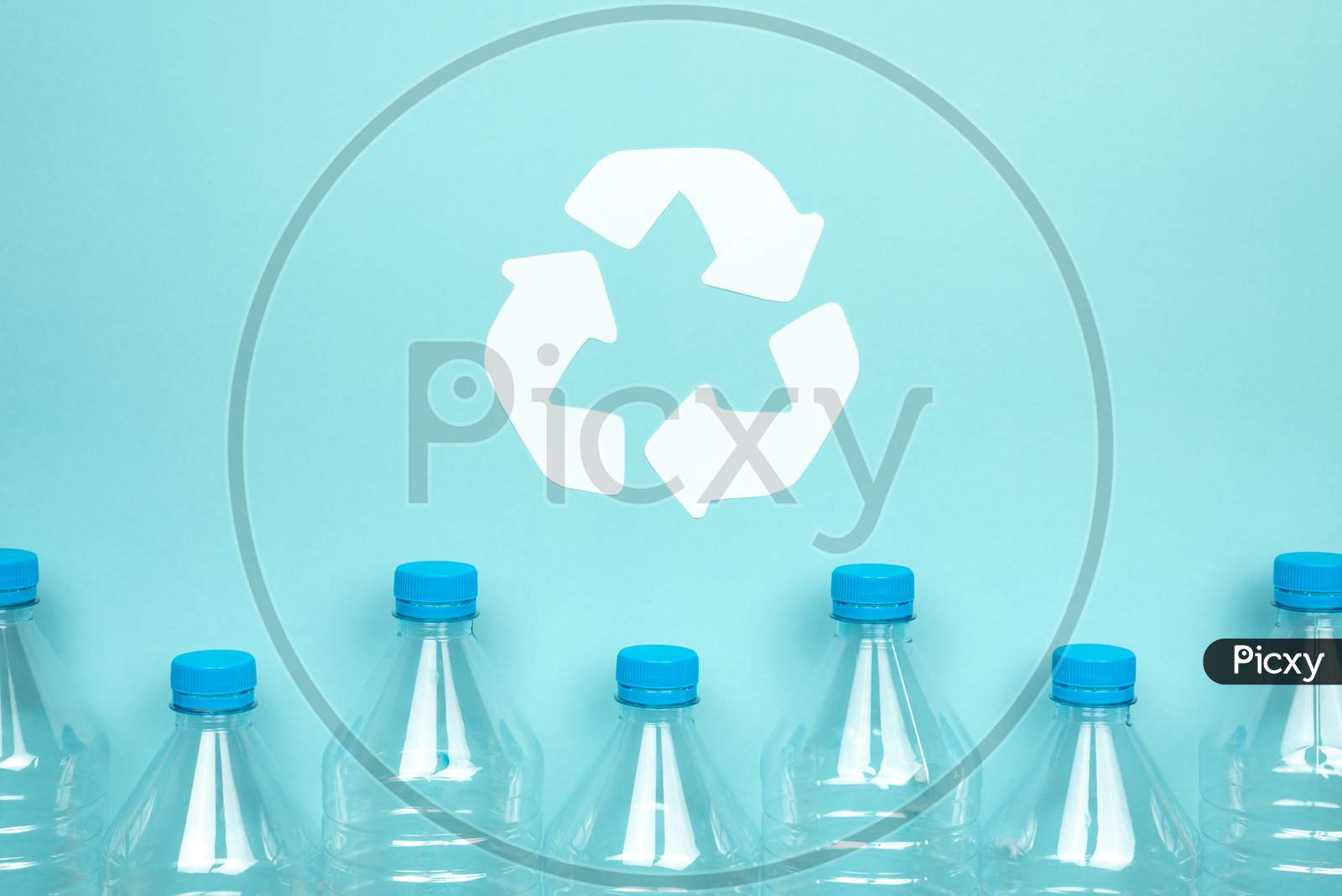 Clear Plastic Bottles With Caps On A Blue Background. Recycling And Environment Concept.
