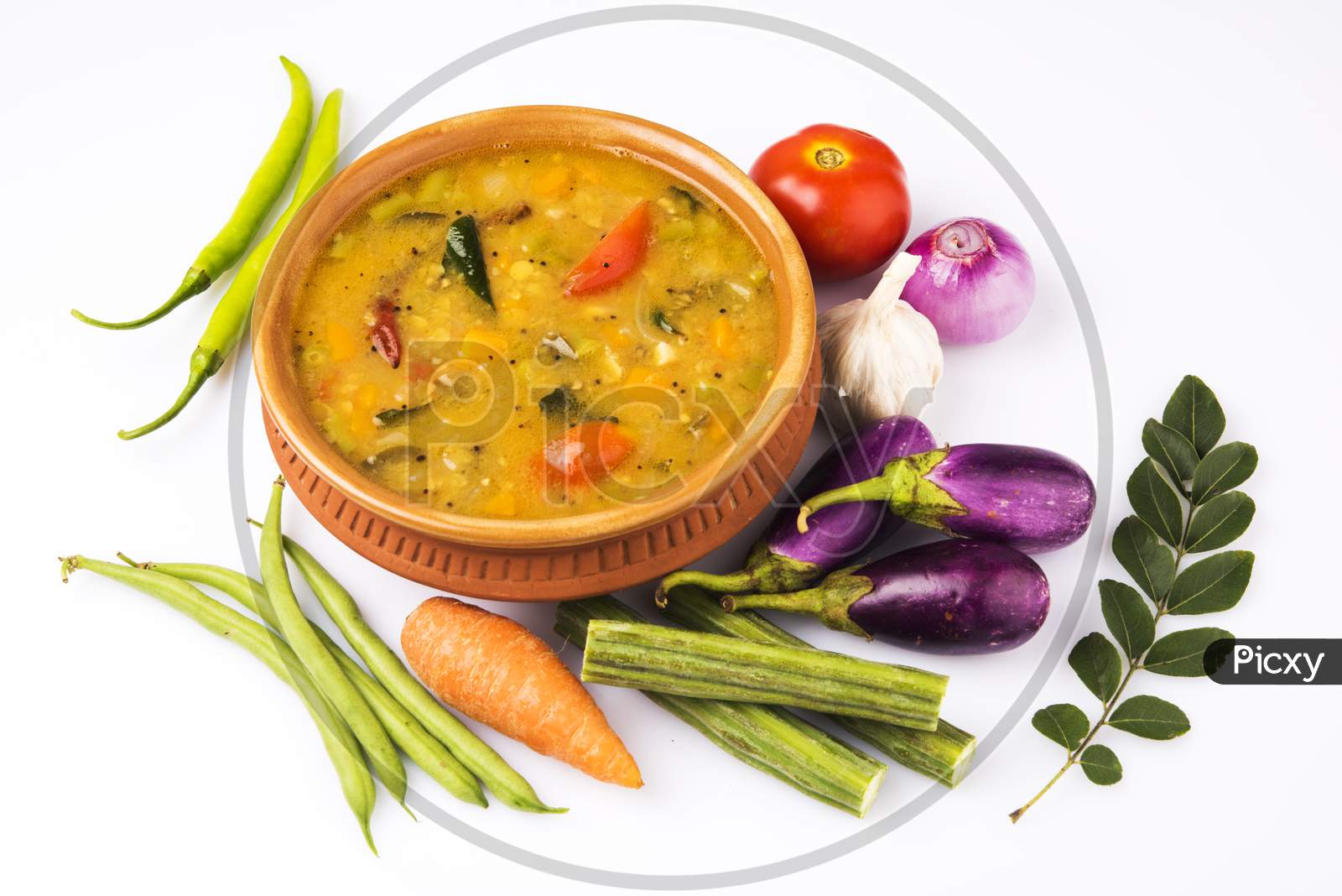 south indian vegetable sambar, in earthen bowl on white background