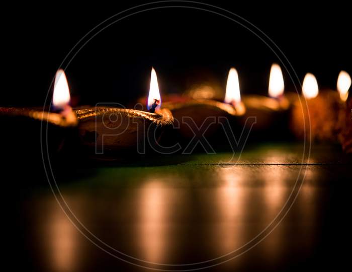 Diwali diyas at night with flowers, lighting series and gifts