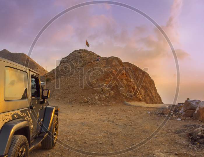 Evening sunset in the mountains of Oman with a vehicle parked for a traveler or trekker.