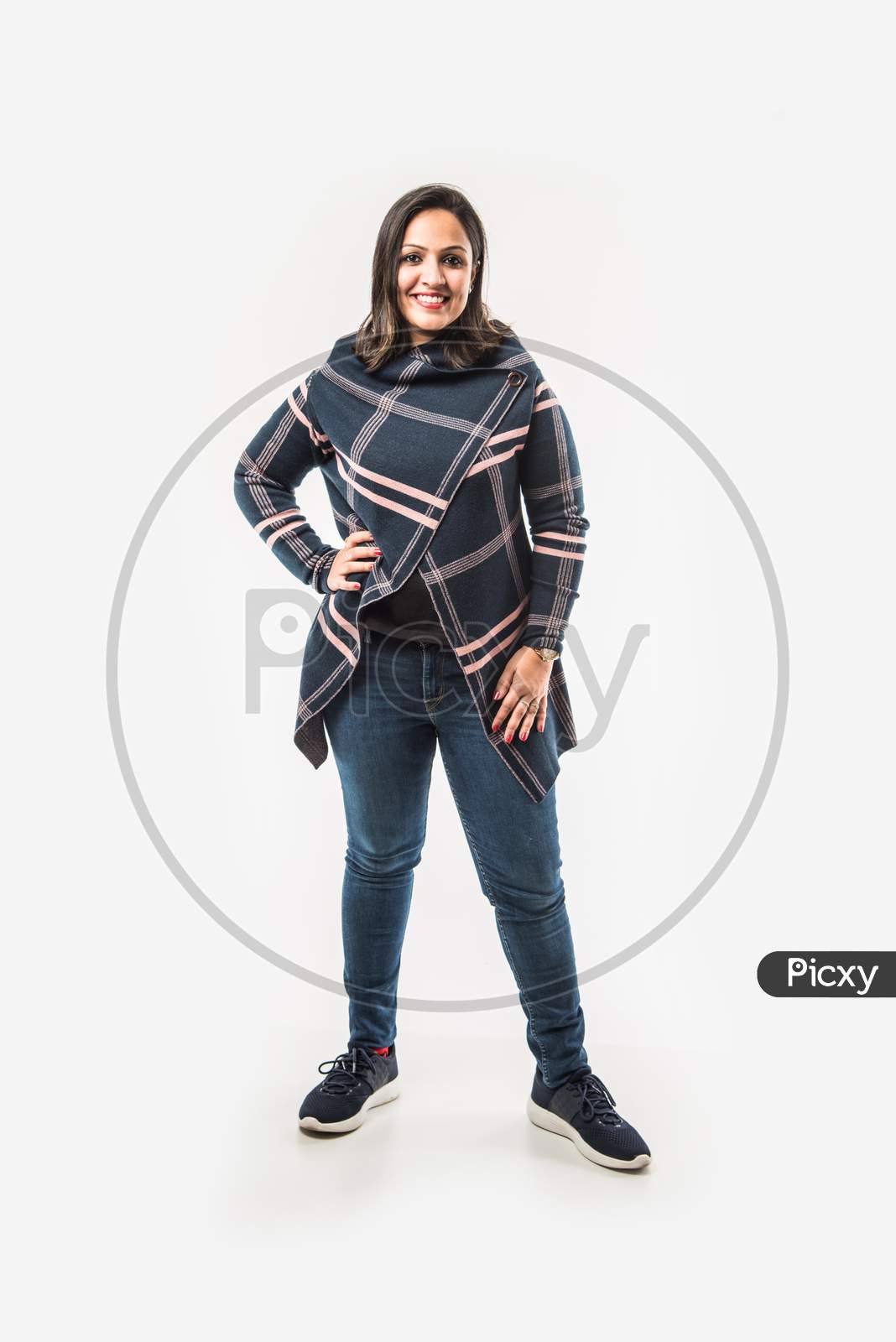 Indian Lady / woman in winter wear presenting or with hands stretched, standing isolated over white background