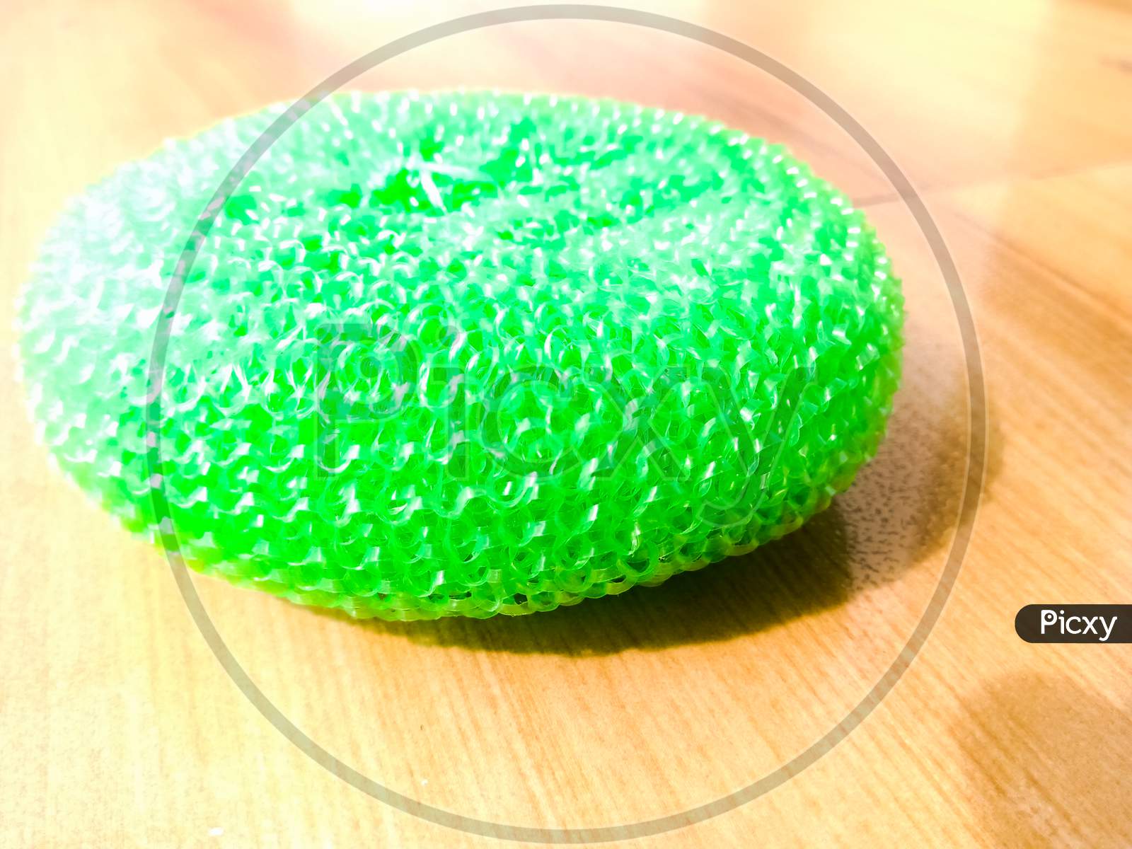 A Green Plastic Scrubber Placed On The Floor.