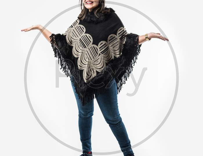 Indian Lady / woman in winter wear presenting or with hands stretched, standing isolated over white background