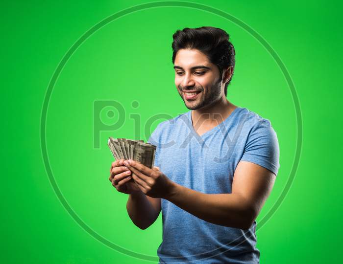 Image of Indian happy man with money fan, standing isolated against ...