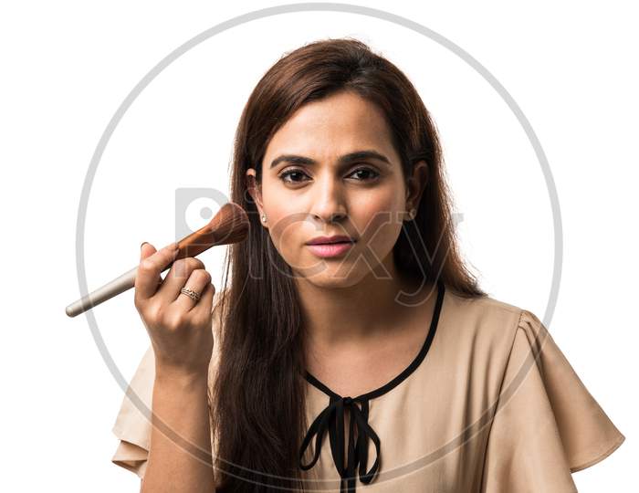 Indian young woman / Girl putting Makeup, standing isolated over white background