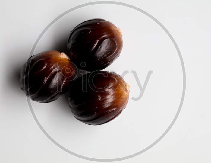 Fresh Brown Color Nutmeg   Seed Kept Against White Background