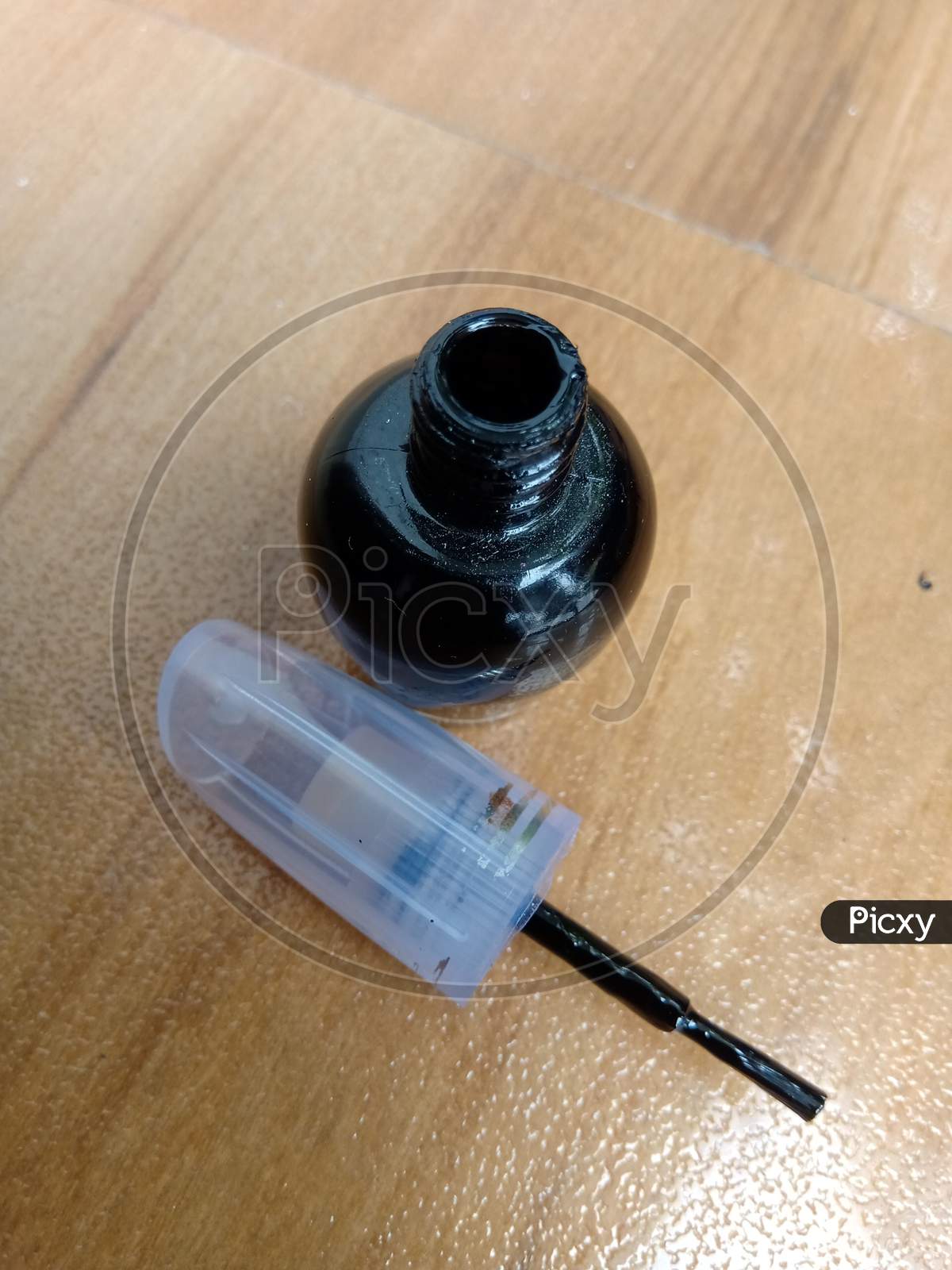 An Opened Black Nail Polish Placed On The Table.