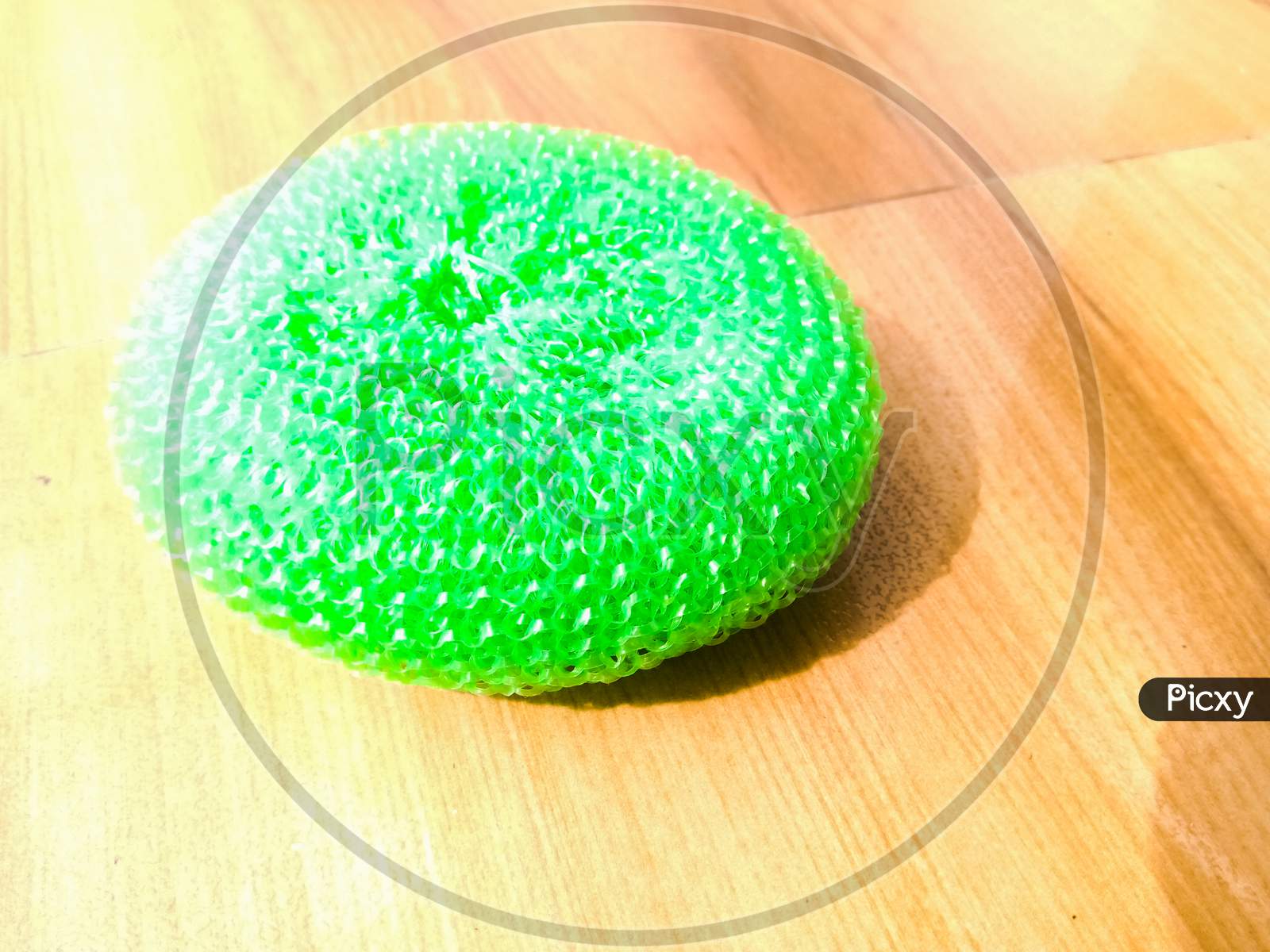 A Green Plastic Scrubber Placed On Floor.