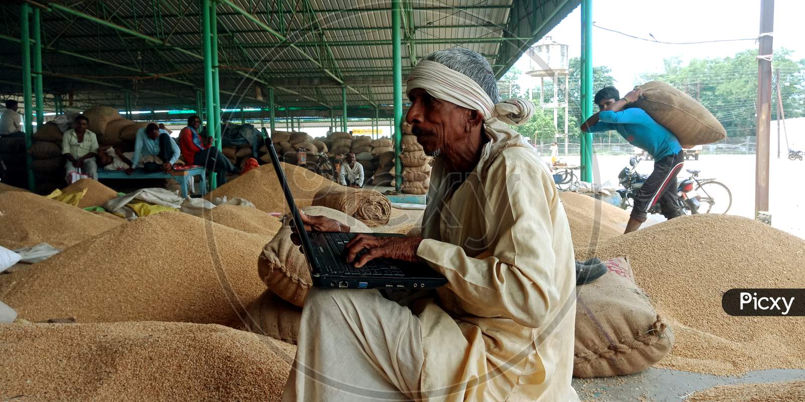 an indian village man operating laptop at farmers place on 2019 in India