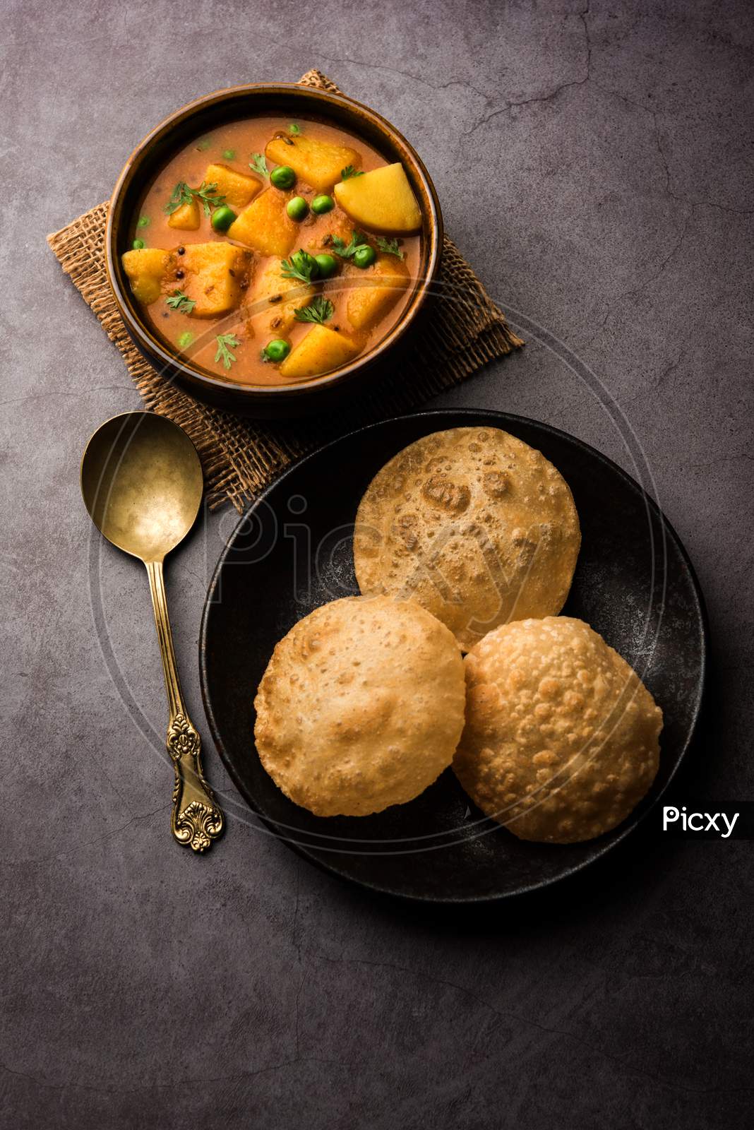 Aloo Puri or Potato curry with fried Poori, popular Indian breakfast / lunch / dinner menu.
