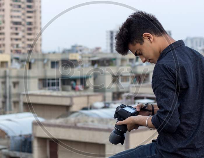 Young Photographer Clicking Photographs At Terrace During World Pandemic. Solo Explorer.