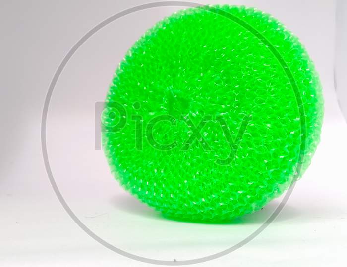 A Green Plastic Scrubber Placed Isolated Vertically On White Background.