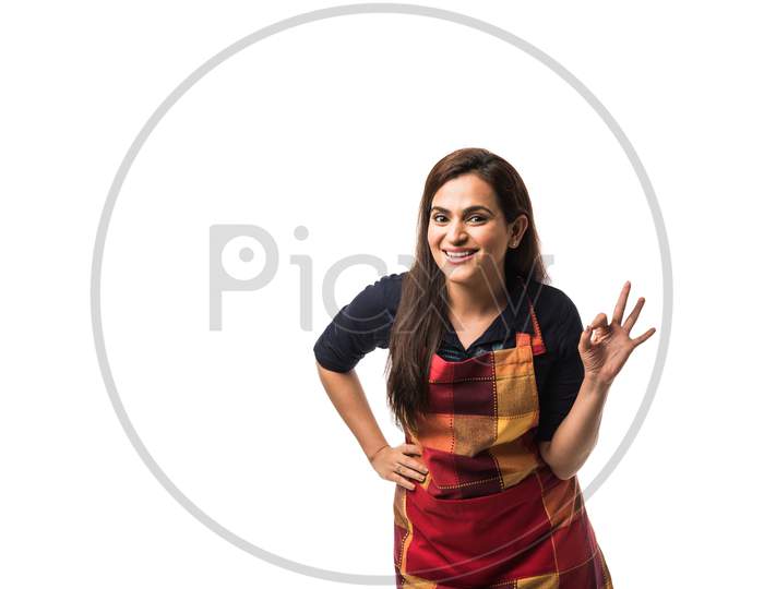 woman chef or cook in apron, presenting, pointing, with ok sign, thumbs up or hands folded